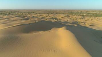 Drönare flygande mjukt på hög höjd över havet över sand sanddyner i öken. antenn se. video