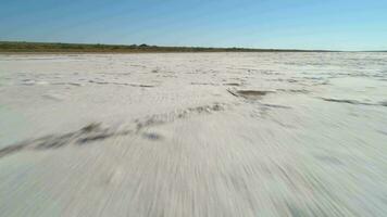 extrêmement faible angle vite en volant plus de sel Lac avec dépôts de blanc sel et fissures. aérien voir. video