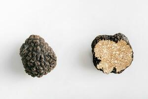 Macro shot of black truffle mushroom full and cut isolated on white background photo