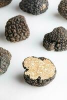 Macro shot of black truffle mushroom full and cut isolated on white background photo