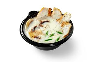 Thai soup tom kha gai with coconut milk, chicken, mushrooms and green scallion photo