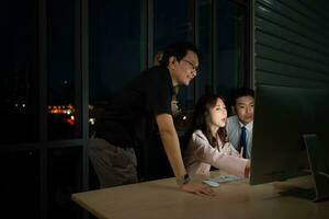 Group of business people working in office at night. Business concept. photo