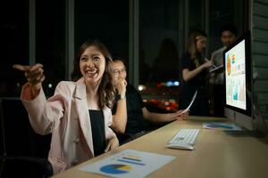 Group of business people working in office at night. Business concept. photo