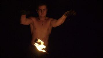 Muscular caucasian man is performing fire show with tricks. Slow motion. video