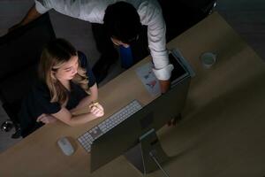 Top view of young Asian broker international stock traders working together on desktop at night office, International financial investment company concept photo