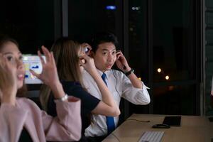 Group of broker international stock traders wearing headset working actively at night in office, Concept of customer support agent provide service on telephone. photo