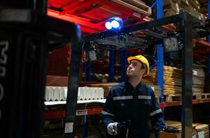 Warehouse workers using forklift to move products in a large warehouse. This is a large paper package storage and distribution warehouse. photo