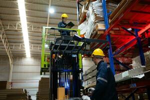 Warehouse workers using forklift to check and counting in a large warehouse. This is a large paper package storage and distribution warehouse. photo