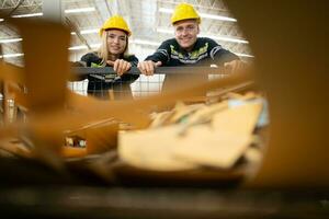 dos fábrica trabajadores trabajo en un depósito, emprendedor un papel carro a ser reciclado foto