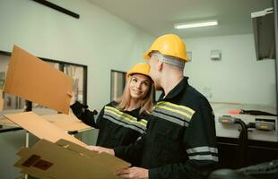 Warehouse workers in uniform and hardhats working in a paper factory photo