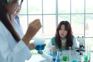 In the science classroom, an Asian child scientist experimenting with scientific formulas with chemicals photo