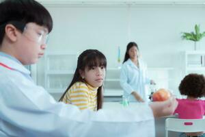 In the science classroom, an Asian child scientist experimenting with scientific formulas with chemicals photo