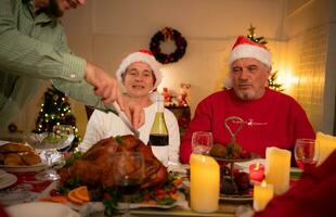 de cerca de mayor Pareja mientras mi hijo estaba el cortar arriba un asado Turquía para Navidad cena. foto