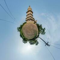 hindu temple of ganesh god of wisdom and prosperity with head of elephant in jungle in Indian tropic village on little planet in blue sky, transformation of spherical 360 panorama. photo