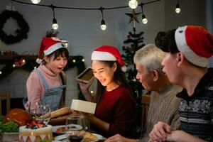 Happy Asian family celebrating Christmas at home. with the activity of giving gifts to each other among family members photo