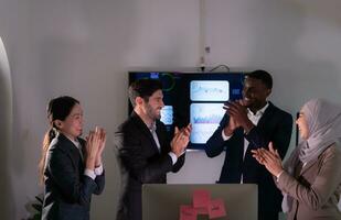 Group of business people discussing the charts and graphs showing the results of their successful teamwork, Emotions of business people who work successfully photo