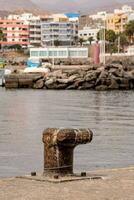 a rusty metal object sitting on the edge of a pier photo