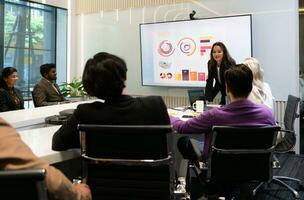 mujer de negocios dando presentación a un grupo de personas en un conferencia habitación foto