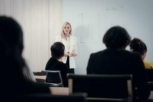 Businesswoman giving presentation to a group of people in a conference room photo