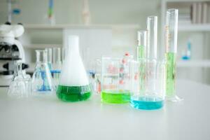 Laboratory glassware with test tubes on table, science background photo