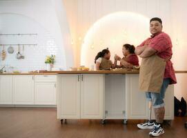 un talla extra familia con un padre vistiendo un protésico pierna, comer juntos después Cocinando y hija bebidas Leche para salud en el comida habitación de el casa foto