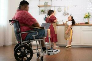 A plus-size family with a father wearing a prosthetic leg, They happily make breakfast together in the in the kitchen room of the house photo