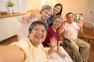 Group of Asian senior and caregiver having fun with selfie in the nursing home. photo