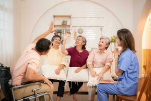 Group of elderly and senior man in wheelchair with nurse at nursing home Play a fun game of hitting each other's hands. Elderly people in nursing home concept photo