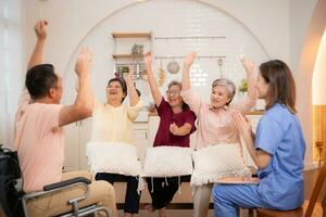 Group of elderly and senior man in wheelchair with nurse at nursing home Play a fun game of hitting each other's hands. Elderly people in nursing home concept photo