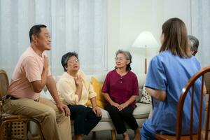 Group of elderly and Asian senior man having a conversation with nurse in the retirement home photo