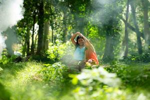 Two girls Asian women with traditional clothing stand had fun playing together in the rainforest. photo