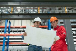 retrato de dos ingeniero que se discute planos de eléctrico tren maquinaria antes de pasando regular inspección después siendo usado para transportar pasajeros para un período de hora foto