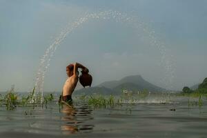 Fishermen using traditional fishing equipment After catching fish, clean up and play in the water. photo