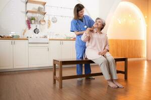 Asian nurse taking care of senior woman in nursing home. Healthcare and medical service. photo