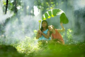 Two girls Asian women with traditional clothing stand had fun playing together in the rainforest. photo