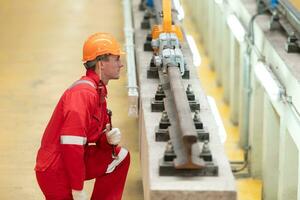 después el eléctrico tren es estacionado en el eléctrico tren reparar comercio, un eléctrico tren técnico con herramientas inspeccionar el ferrocarril y eléctrico trenes en conformidad con el inspección redondo foto