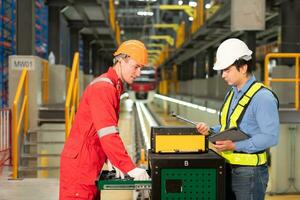 Electric train engineer and technician using repair tools of the electric train industry There is an electric train in the train repair factory as the background image. photo