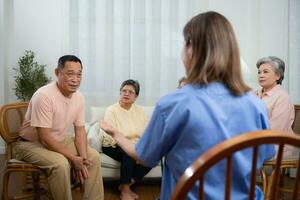 grupo de mayor y asiático mayor hombre teniendo un conversacion con enfermero en el Jubilación hogar foto