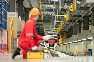 retrato de ingeniero utilizando reparar herramientas de el eléctrico tren industria allí es un eléctrico coche en el coche reparar fábrica como el antecedentes imagen. foto