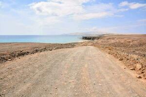 a dirt road leading to the ocean photo