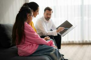 Psychotherapist working with child patient and mother in office, Concept of psychotherapy photo