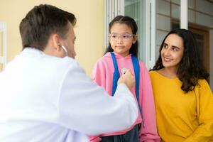 médico con estetoscopio examinando niño paciente en hospital. cuidado de la salud y médico concepto. foto