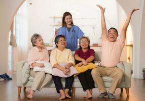 grupo de asiático mayor y cuidador teniendo divertido en el enfermería hogar. foto