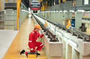 After the electric train is parked in the electric train repair shop, an electric train technician with tools inspect the railway and electric trains in accordance with the inspection round photo