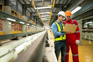 After the electric train parked in the electric train repair shop, Engineer and electric train technician with laptop inspect the railway and electric trains in accordance with the inspection round photo