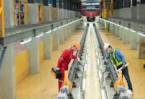 After the electric train is parked in the electric train repair shop, Electric train engineer and technician with tools inspect the railway and electric trains in accordance with the inspection round photo