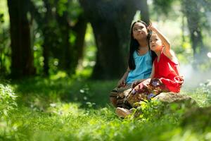 Two girls Asian women with traditional clothing stand had fun playing together in the rainforest. photo