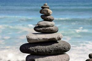 a stack of rocks by the ocean photo