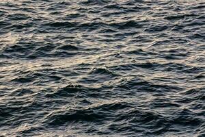 the ocean is dark with small waves photo