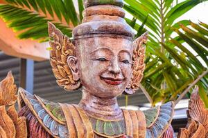 a wooden statue of a buddha with a smile photo